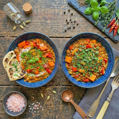 veganes Rotes Linsen Dal als roteinreiches Rezept für gesundes Mittagessen oder Abendessen angerichtet auf 2 Tellern